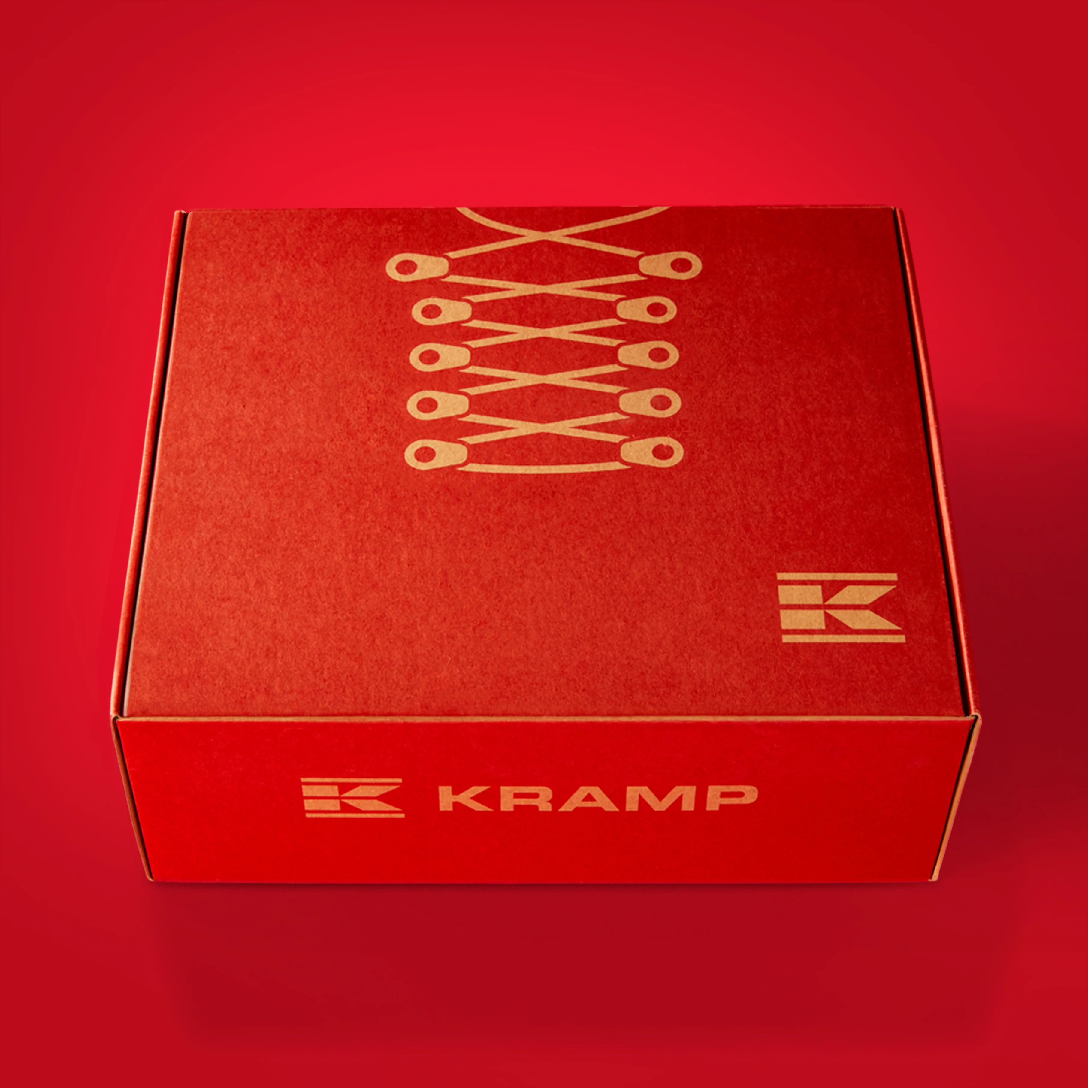 Red Kramp shoe box, shot at a 3/4 angle, against a red background.